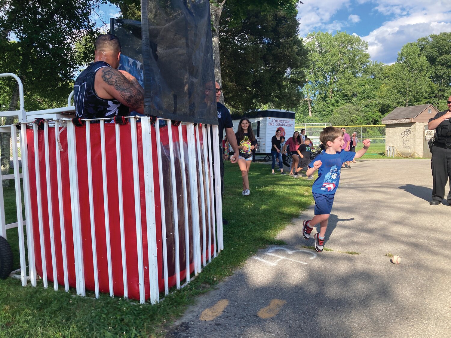 DUNK A COP: Children were thrilled to take their chance at hitting the target and dunking School Resource Officer Louis Cotoia into the cold waters of the dunk tank.